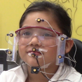 Female child with glasses doing a test while hooked up to sensors