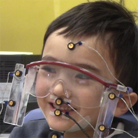 Male child with glasses doing a test while hooked up to sensors