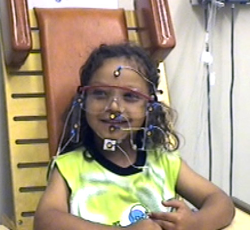 Female child with glasses doing a test while hooked up to sensors