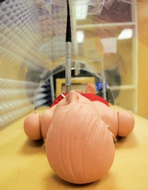 A dummy laying down with a mic hanging above it.